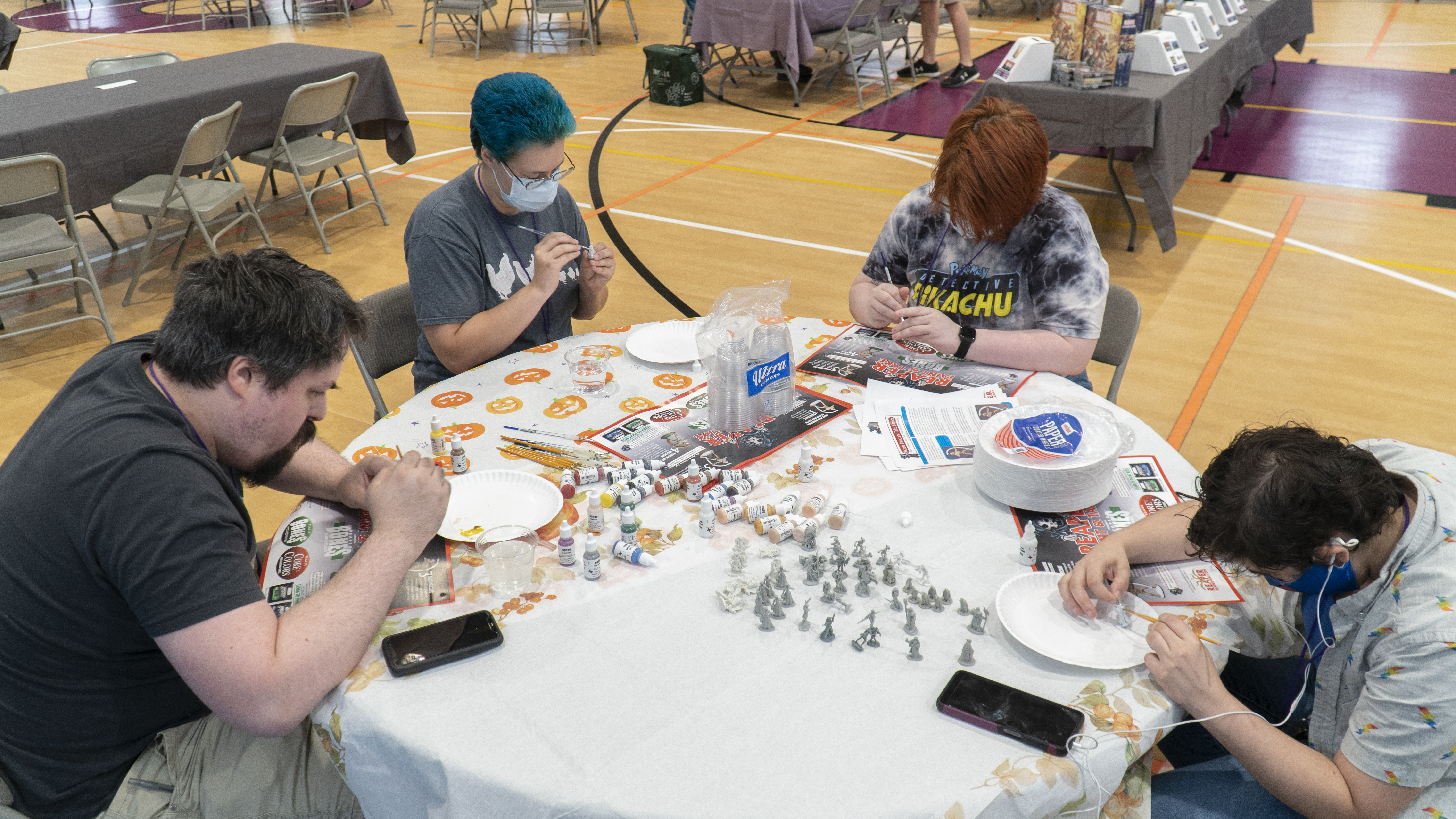 People sitting around a table painting miniatures